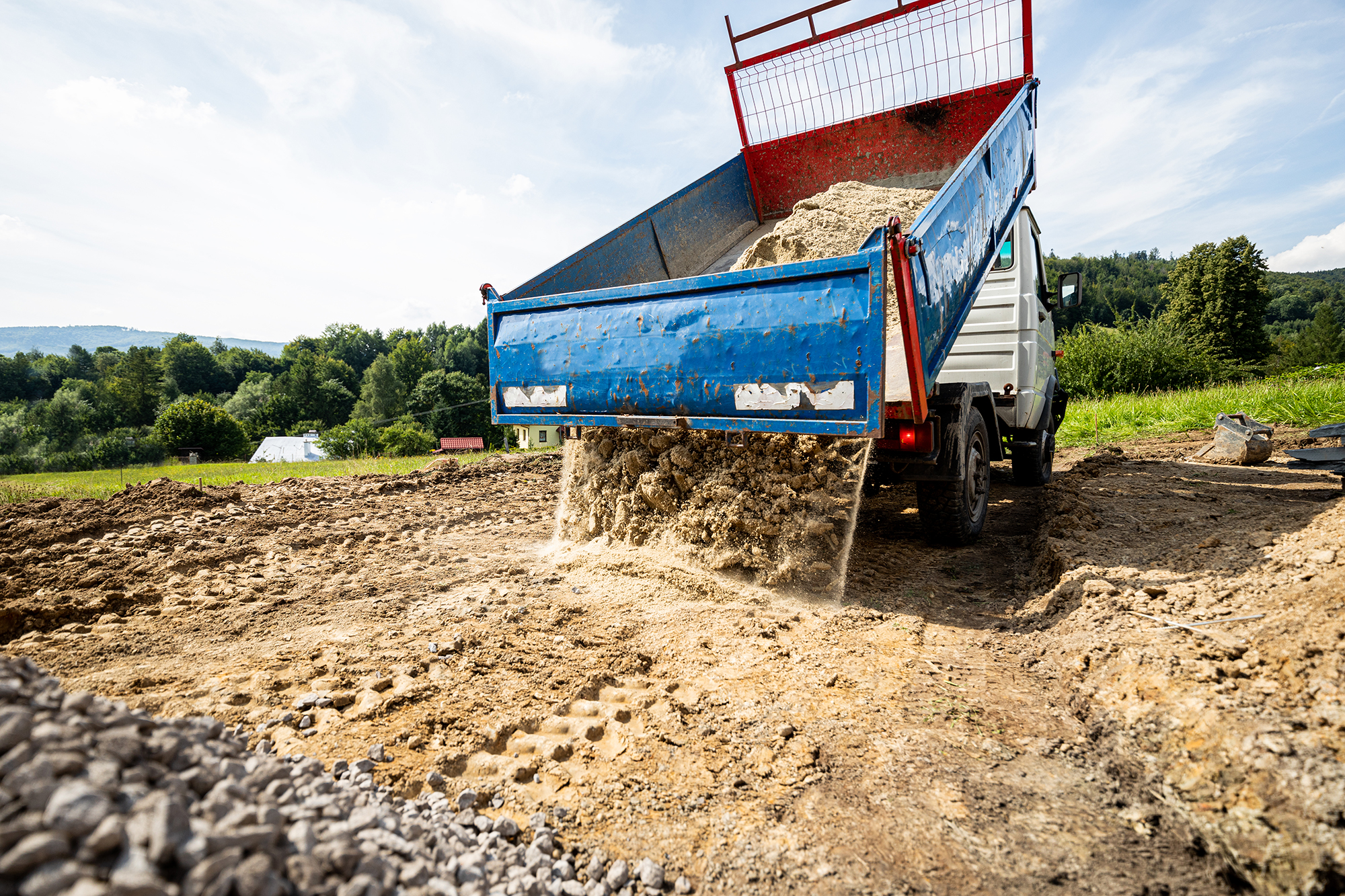 Unloading the truck with the soil and sand at construction site